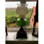 Oil lamp, green glass bowl, cast iron base.