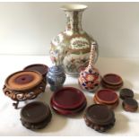 Three Oriental vases together with hardwood display stands.