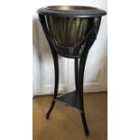 An Edwardian ebonized plant stand.