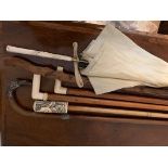 Five old walking sticks and an umbrella inc. unmarked silver handle, ivory etc.