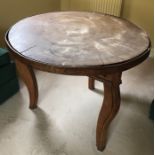 An unusual wooden table made of a cross section of tree trunk on associated base.