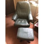 Green leather recliner and stool.