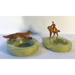 Two onyx and cold painted bronze ashtrays mounted with huntsman and fox. Chips to onyx.