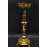 AN ECCLESIASTICAL STYLE CANDLE HOLDER, with pierced triform decorated rim, a reeded column, circular