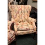 A WING BACK ARM CHAIR, with floral upholstery