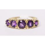 A 9CT YELLOW GOLD AMETHYST 5 STONE RING