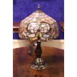 A TIFFANY STYLE TABLE LAMP, with multi coloured shade and shaped column with circular base, 19" tall