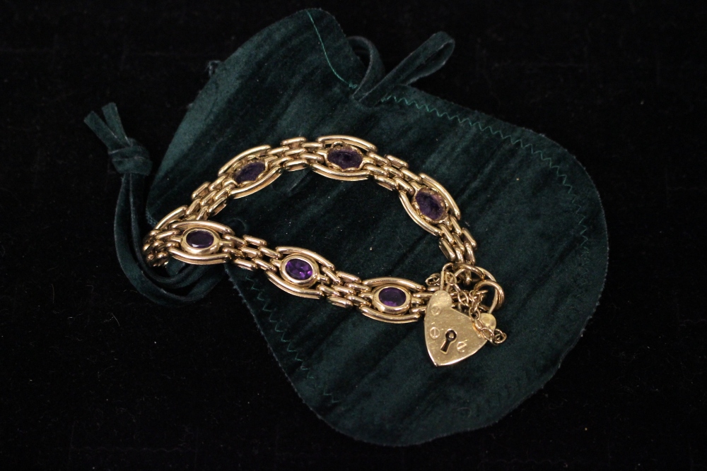 A 9CT GOLD LINK BRACELET, with heart shaped lock and pink stones