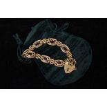 A 9CT GOLD LINK BRACELET, with heart shaped lock and pink stones