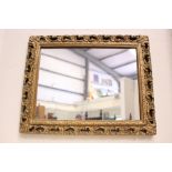 A GILT WALL MIRROR, rectangular in shape, with pierced frame, having scroll and foliage detail,