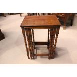 AN OAK NEST OF TABLES, (3) sizes, raised on bobbin turned legs, with square stretcher uniting, top