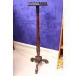 A VICTORIAN MAHOGANY TORCHÉRE STAND, with octagonal top having a carved foliage rim and reeded &