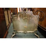 GOOD QUALITY EARLY 20TH CENTURY BRASS MESH FIRE GUARD on chased, decorative legs, with ribbon