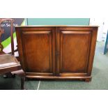 A 20TH CENTURY TWO DOOR FLOOR CABINET, with crossbanded top, canted sides, raised on bracket feet,