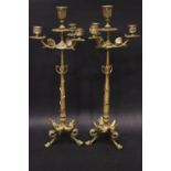 A PAIR OF GILT BRASS FOUR LIGHT CANDELEBRA, with floral and leaf decoration raised on tripod claw