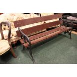 A LARGE GARDEN BENCH / SEAT, with cast iron grape vine arm rests and out swept leg, 66" x 24" x 28.