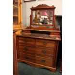 AN EDWARDIAN DRESSING TABLE, having a swing mirror with reeded frame, surmounted with carved