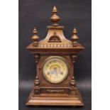 AN OAK CASED LATE 19TH CENTURY MANTLE CLOCK, surmounted with turned finials, with brass frame to