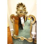 GILTWOOD OVERMANTLE OR PIER MIRROR in a shaped form, surmounted by plume, having reeded decoration