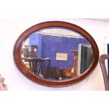 AN OVAL MAHOGANY WALL MIRROR, with gadrooned rim, 38" x 26.5" approx