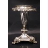 A SILVER PLATED VASE, with vine and leaf rim, up turned scroll tipped feet, with acanthus leaf