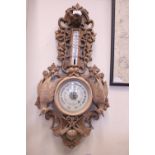 A LATE 19TH CENTURY 'BLACKFOREST STYLE' WALL BAROMETER, case is extensively carved with dog's head