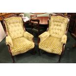 A PAIR OF WING BACKED ARM CHAIRS, with carved crest rail detail, on tapered front legs, 42" x 26"