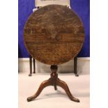 AN 18TH CENTURY TIP UP CENTRE TABLE, with oak top and fruit wood base, a column support on a