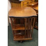 AN EARLY 20TH CENTURY REVOLVING BOOKCASE, with two tier shelving, each with latted sides, the top