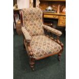 A LARGE EDWARDIAN ARM CHAIR, with scroll tipped armrests, raised with turned pillar supports, on