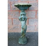 A STONE BIRD BATH raised on a 'cherub' style column base