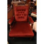 A BUTTON BACKED ARM CHAIR, with carved crest rail, and arm rest supports on turned front leg, and