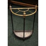 A SEMI CIRCULAR UMBRELLA STAND, with brass divider, cast iron base with triangular motif, 24" x 8" x