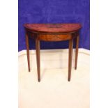 A DEMI LUNE SATINWOOD FOLD OVER CARD TABLE, decorated with hand painted motif of foliage and cherubs