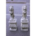 A PAIR OF STONE GARDEN LIONS, on plinth bases, 38" x 11" x 11" approx