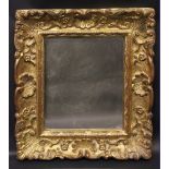 A GILTWOOD WALL MIRROR, with floral and shell decoration, carved scalloped slip, 17" x 14.25" approx