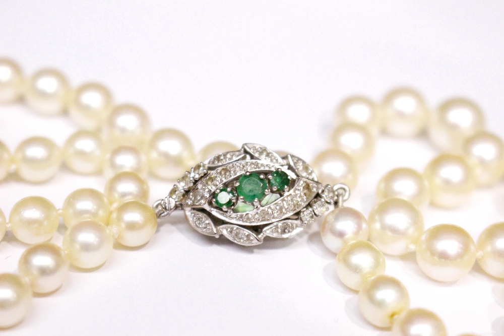A FRENCH PEARL NECKLACE, with platinum and gold clasp, encrusted with diamonds and 3 emeralds