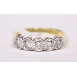 AN 18CT YELLOW GOLD GRADUATED DIAMOND 5 STONE RING, with rub over setting, 1.20cts., VSI G colour