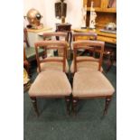 A SET OF FOUR DINING CHAIRS, with reeded and carved detail, raised on turned front legs and sabre