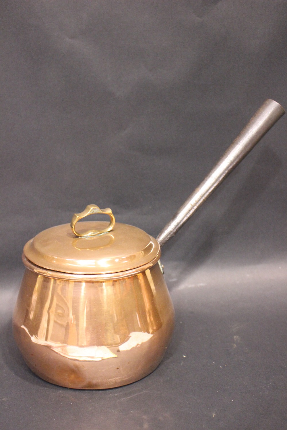 A COPPERWARE POT, with lid and cast iron handle, provenance came from the Bryan & Valarie Steele