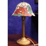 A TIFFANY STYLE DESK / TABLE LAMP, with floral pattern to the glass shade, a cast metal column base,