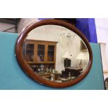 AN EARLY 20TH CENTURY OVAL WALL MIRROR, wooden inlaid frame, with bevelled glass, 32" x 24" approx
