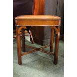 A LOW RISE LAMP TABLE, with raised lip edge, canted legs/corners, united by a pierced 'x' stretcher,