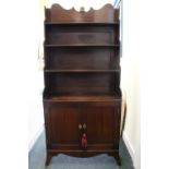 A FINE GEORGE III MAHOGANY ‘WATERFALL’ BOOKCASE CABINET, with three cascading open shelves, enclosed