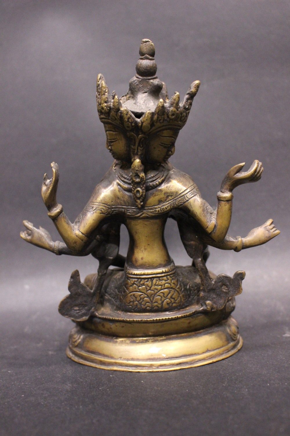 A BRASS FIGURE OF THE BUDDHIST DIETY USHNISHAVIJAYA, with three heads and 8 arms, sitting in the - Image 3 of 3