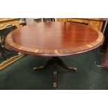 A CIRCULAR DINING TABLE, with crossbanded rim and string inlaid detail, raised on a turned column