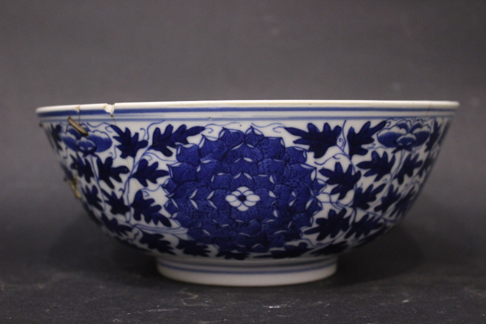 A CHINESE BLUE & WHITE BOWL, the exterior decorated with floral medallions, with a foliate band