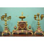 A 19TH CENTURY FRENCH RED MARBLE CLOCK SET, the central clock is decorated with ormolu mounts in the