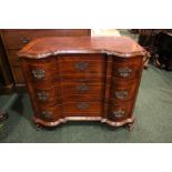 A SERPENTINE SHAPED ROSEWOOD CHEST OF DRAWERS, crossbanded with string inlaid detail, each drawer