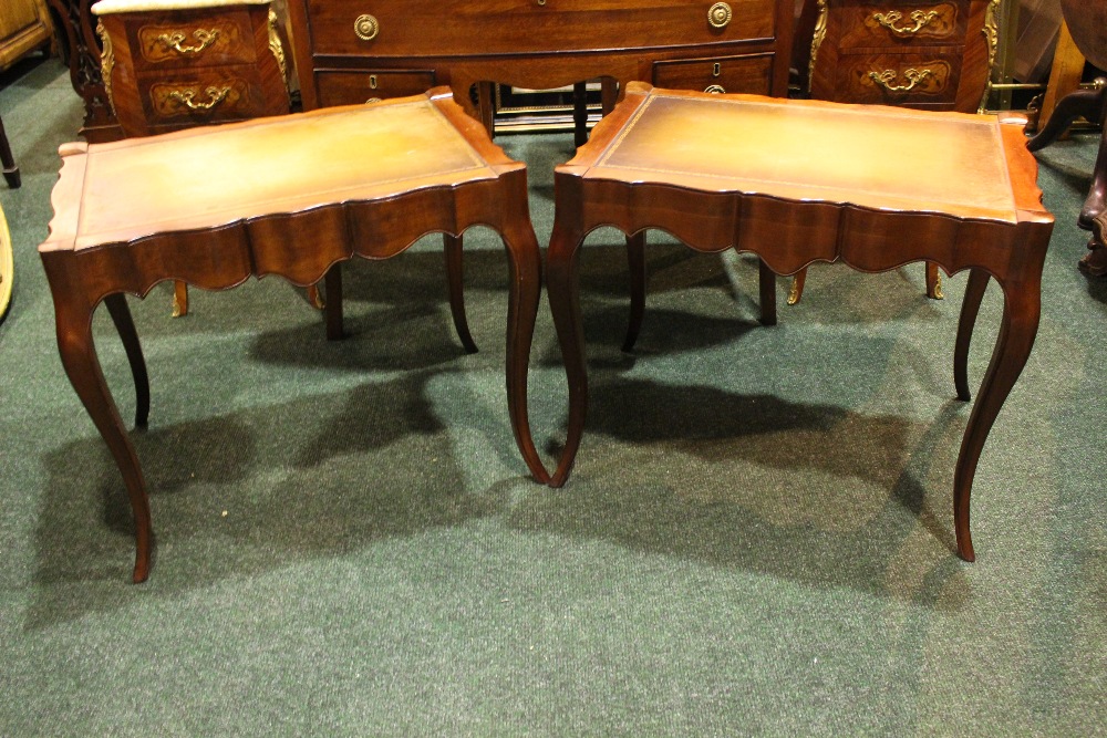 A PAIR OF SERPENTINE SHAPED LEATHER TOPPED TABLES, raised on cabriole shaped legs 26" x 19" x 22"